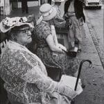 Women in hats sitting and waiting for a bus