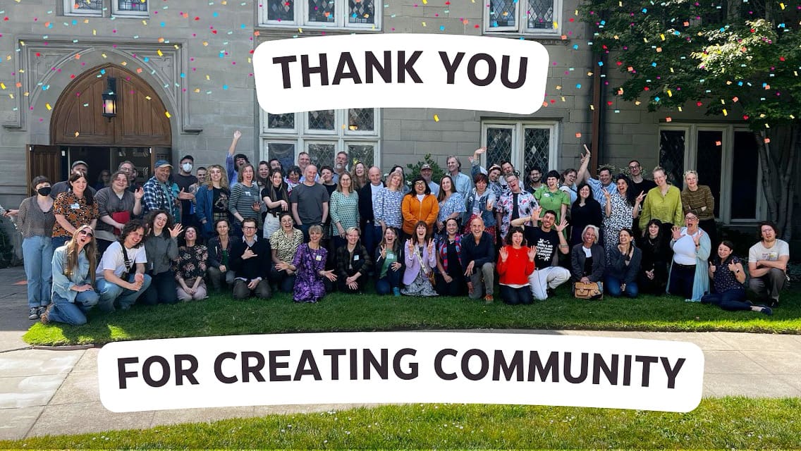 thank you for creating community is written atop a group photo of excited and smiling symposium attendees